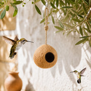 Hangend vogelhuisje van kokosnoot met ingang rond