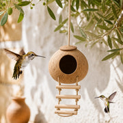 Hangend vogelhuisje van kokosnoot met schommel